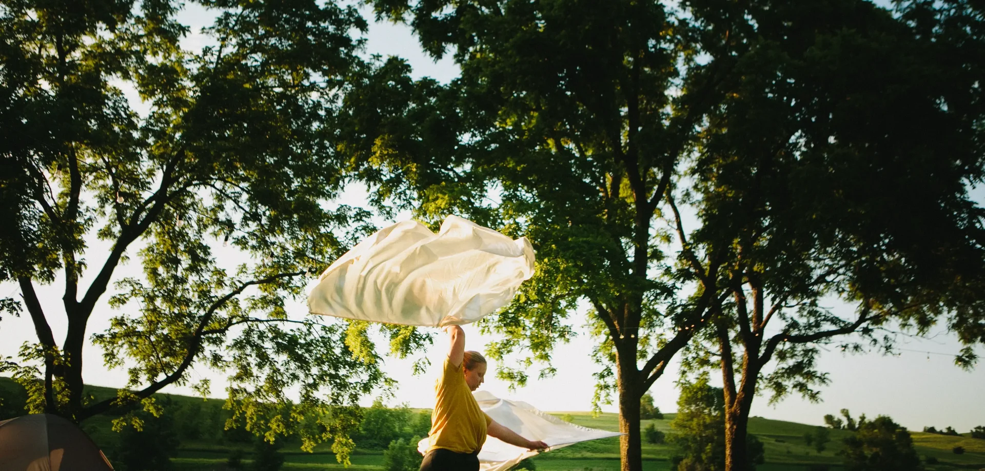 A woman dancing with white fabric outdoors at Proclaim