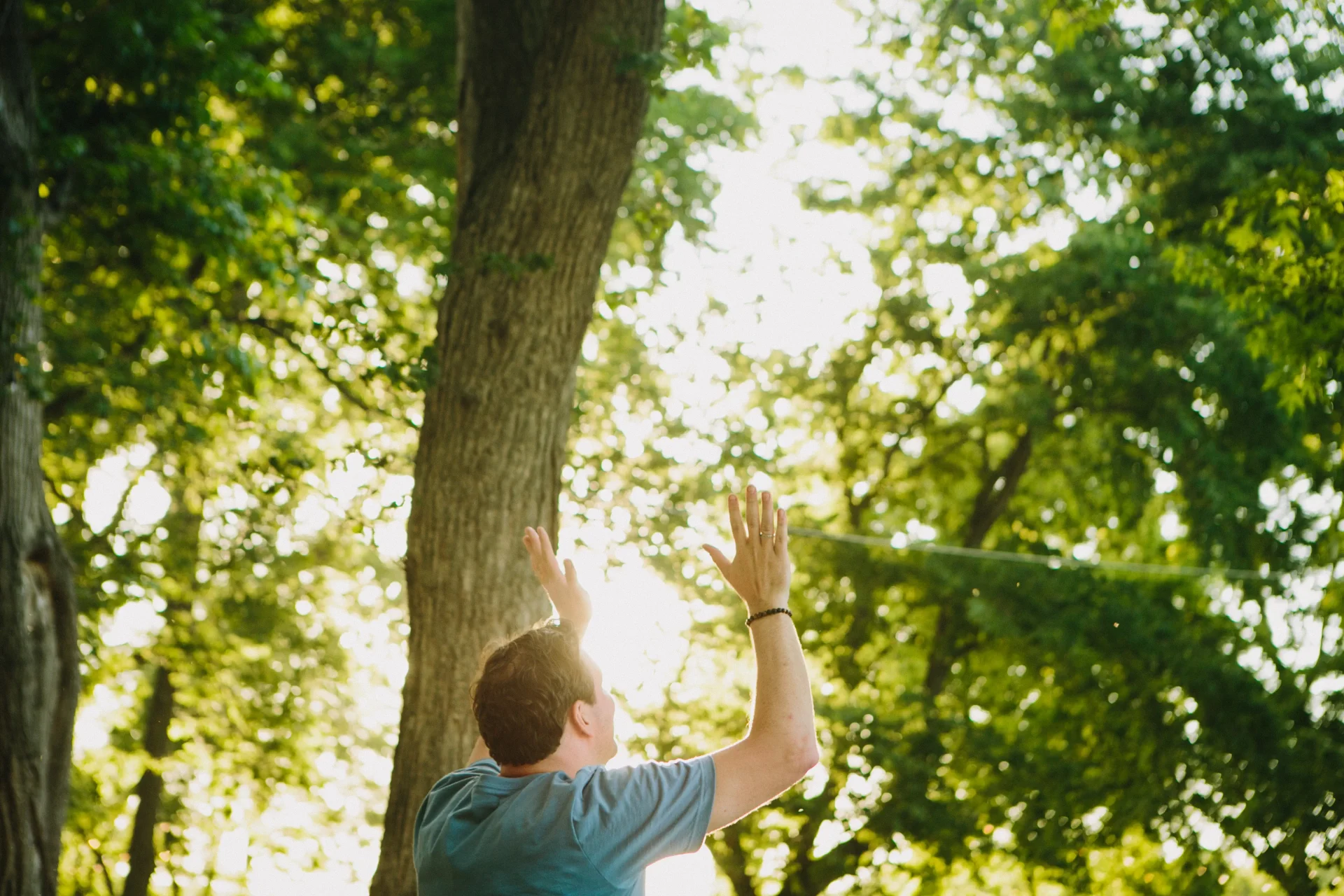 A man raising his hands to God in the outdoors at Proclaim